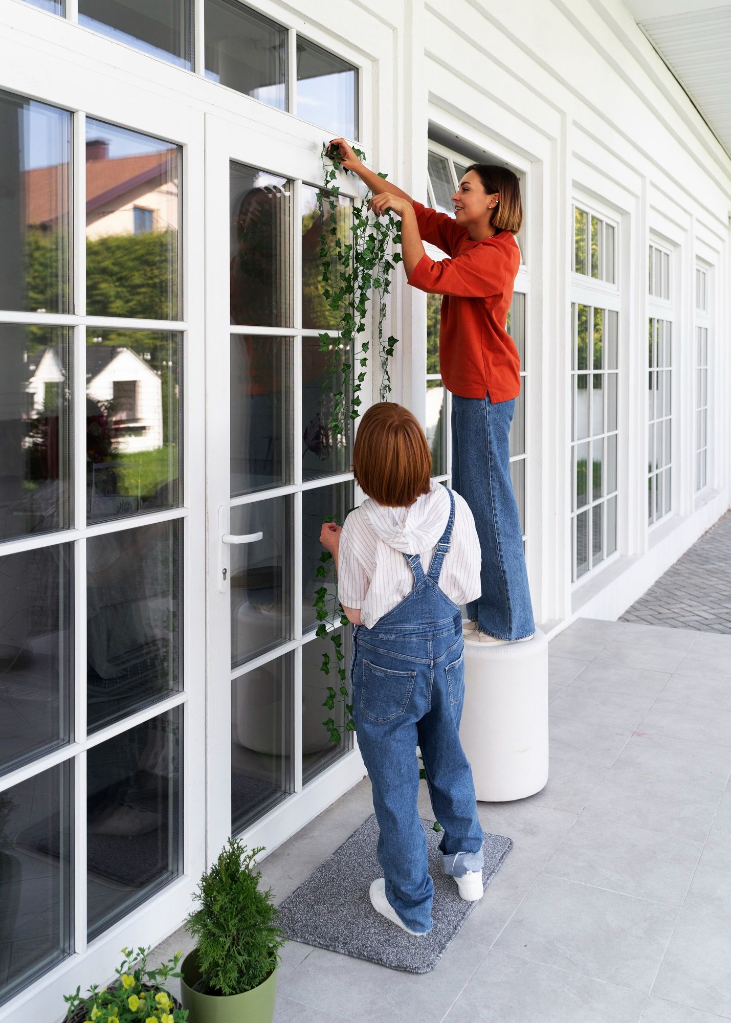 A woman and child are cleaning a sliding glass door