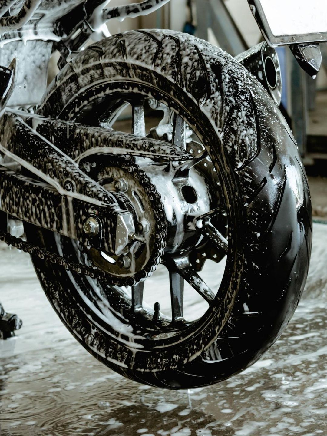 A close up of a motorcycle wheel covered in soap.