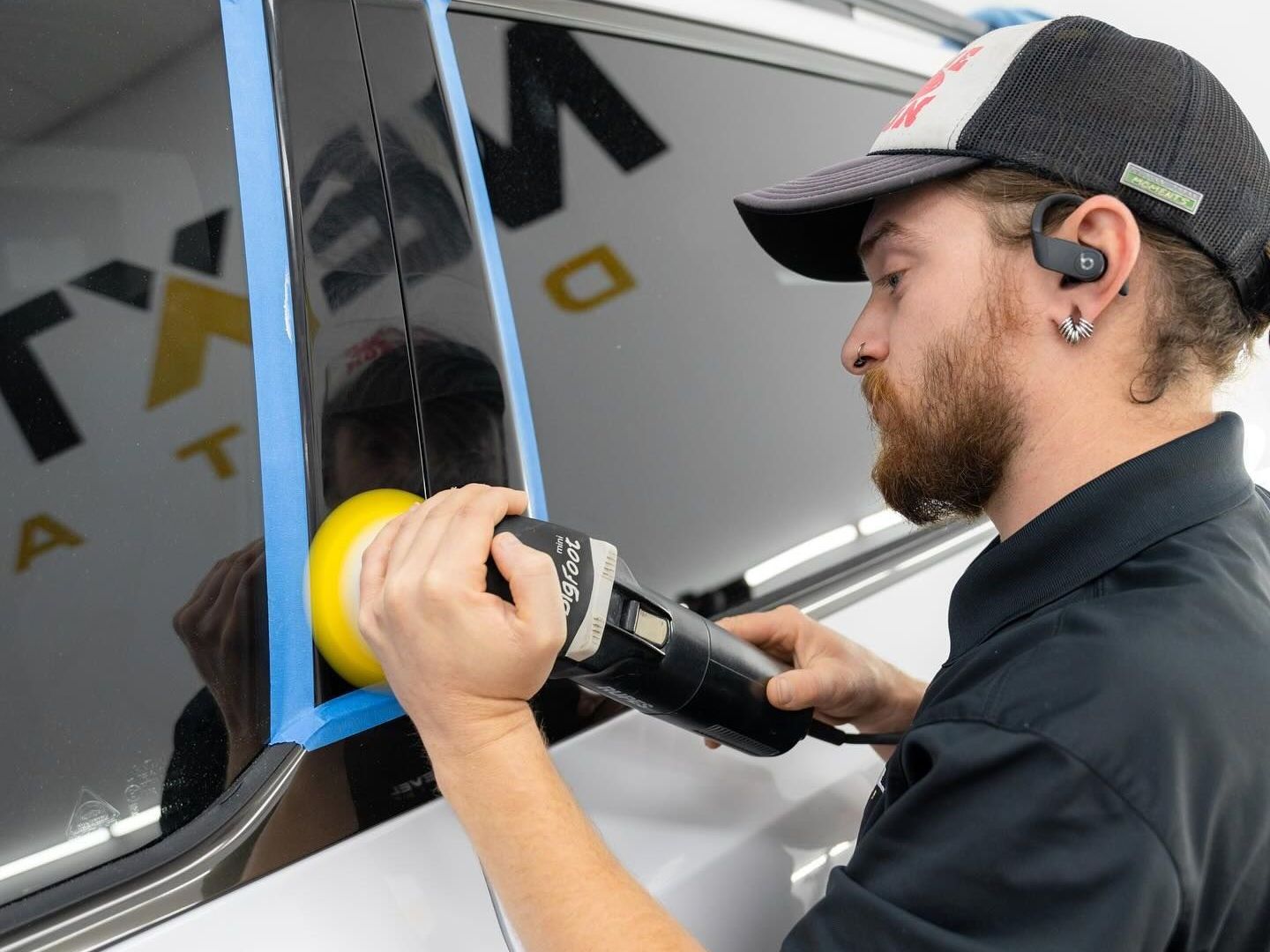 A person is polishing a car with a machine.