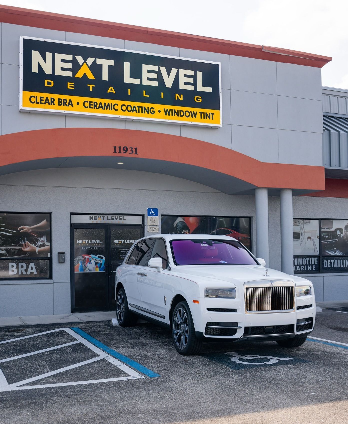 A white Rolls Royce parked in front of 
