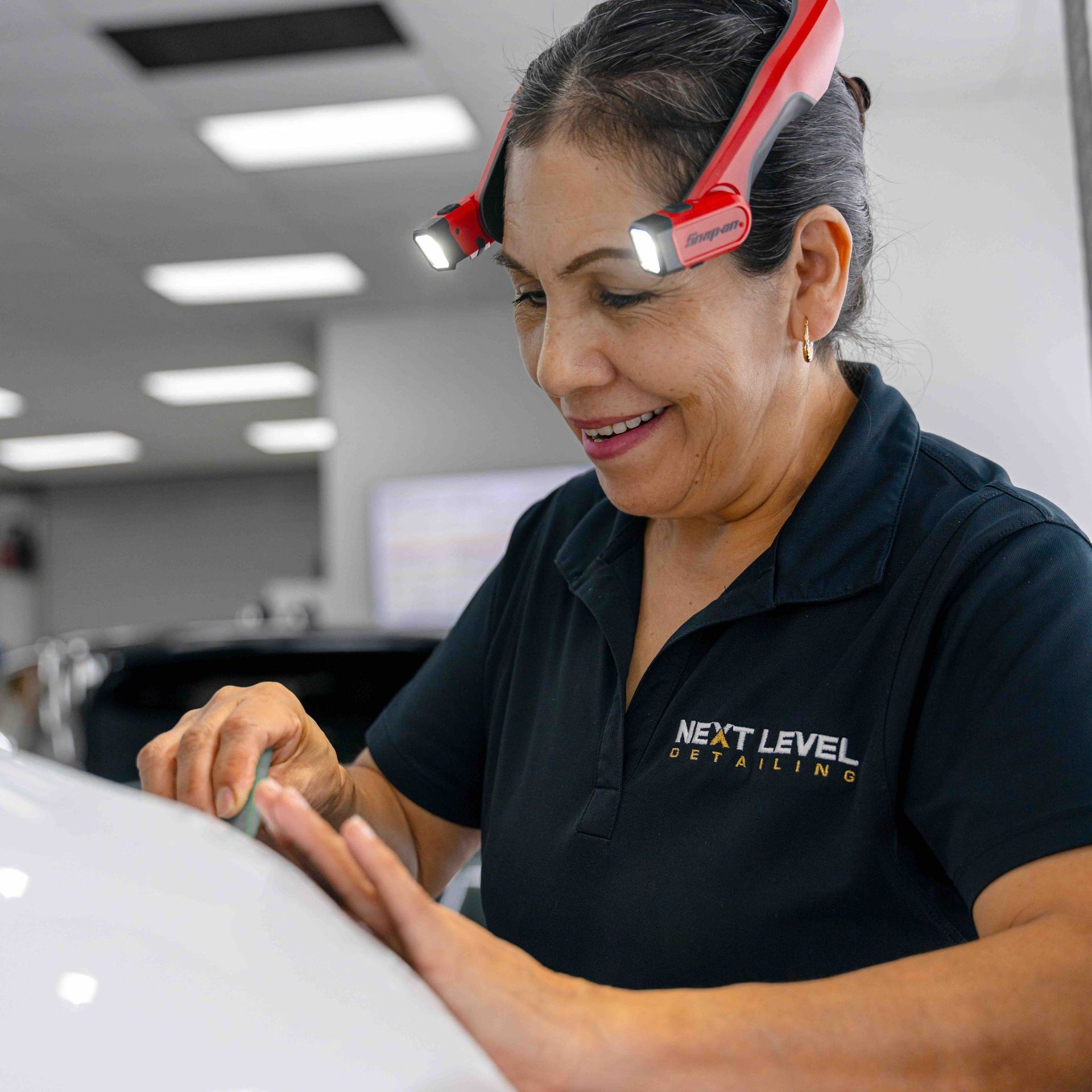 A woman wearing a black shirt that says next level creative