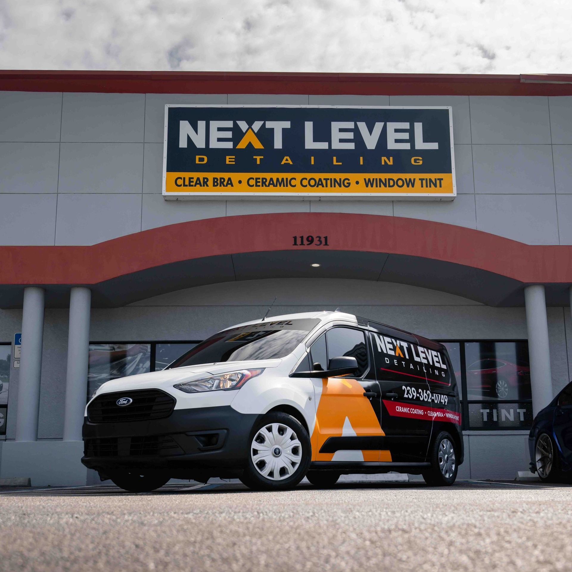 A van is parked in front of a building that says next level detailing