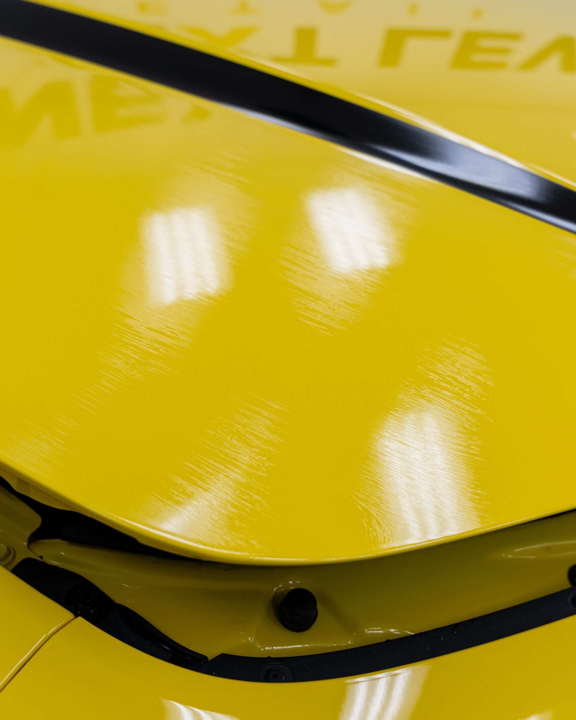 A close up of the hood of a yellow car.
