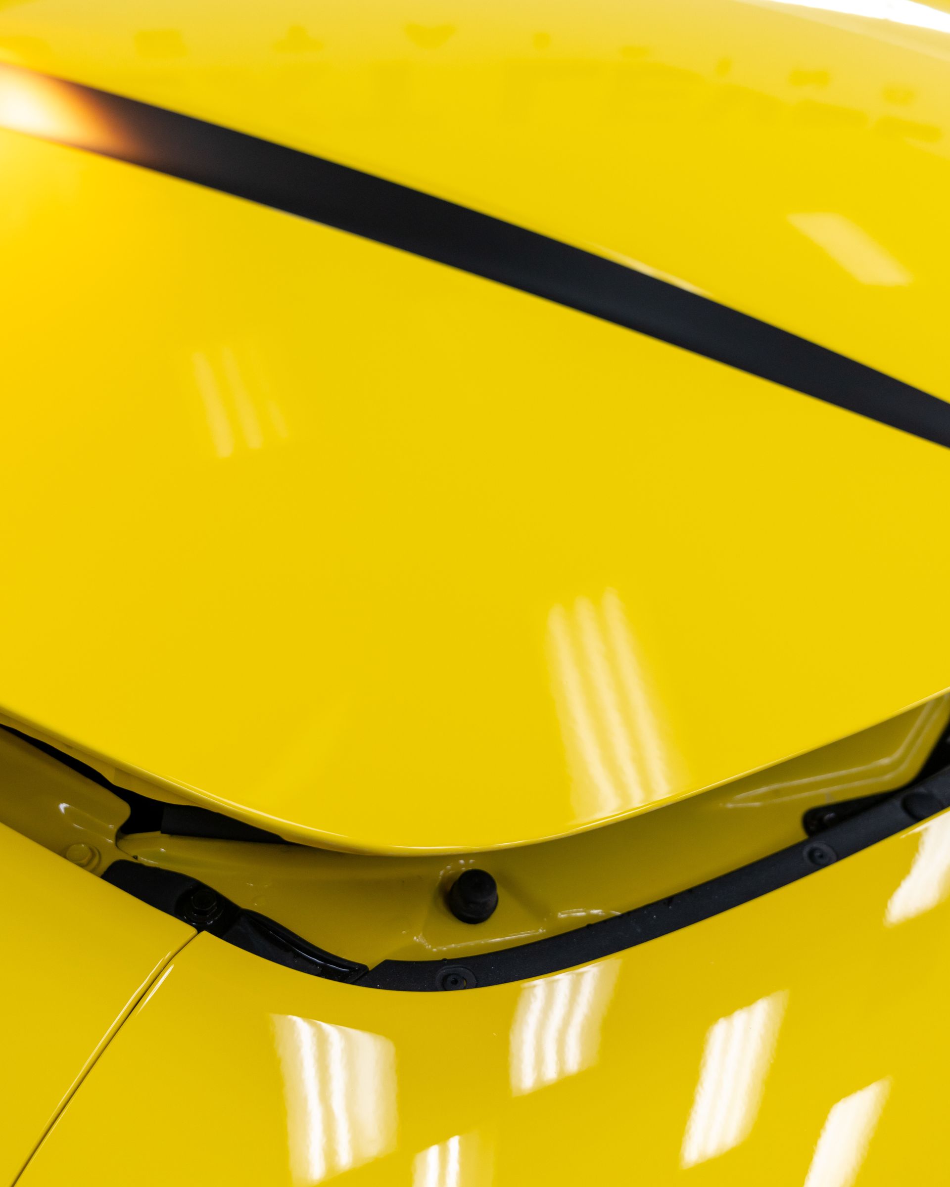 A close up of the hood of a yellow car