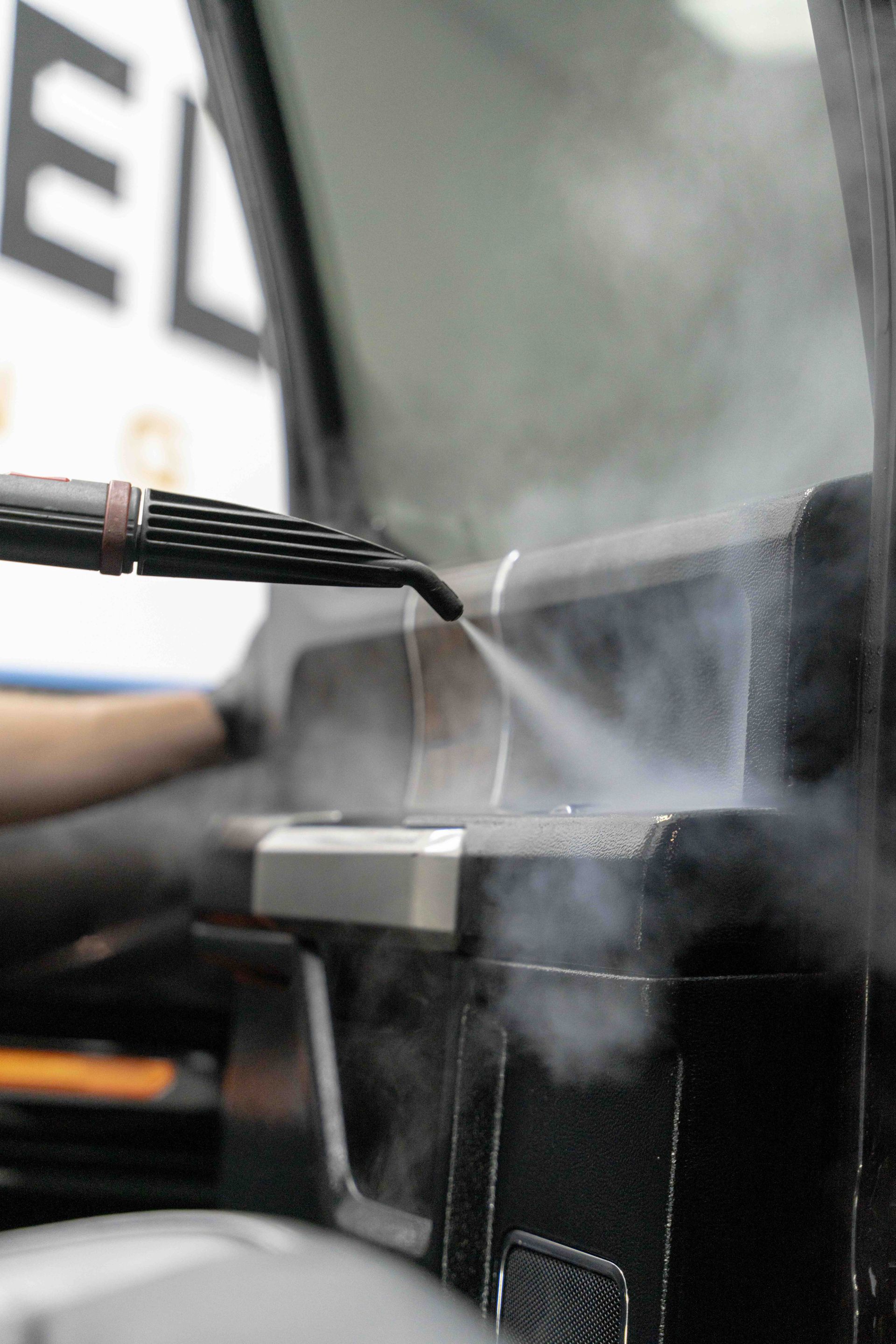A person is spraying water on a piece of metal.