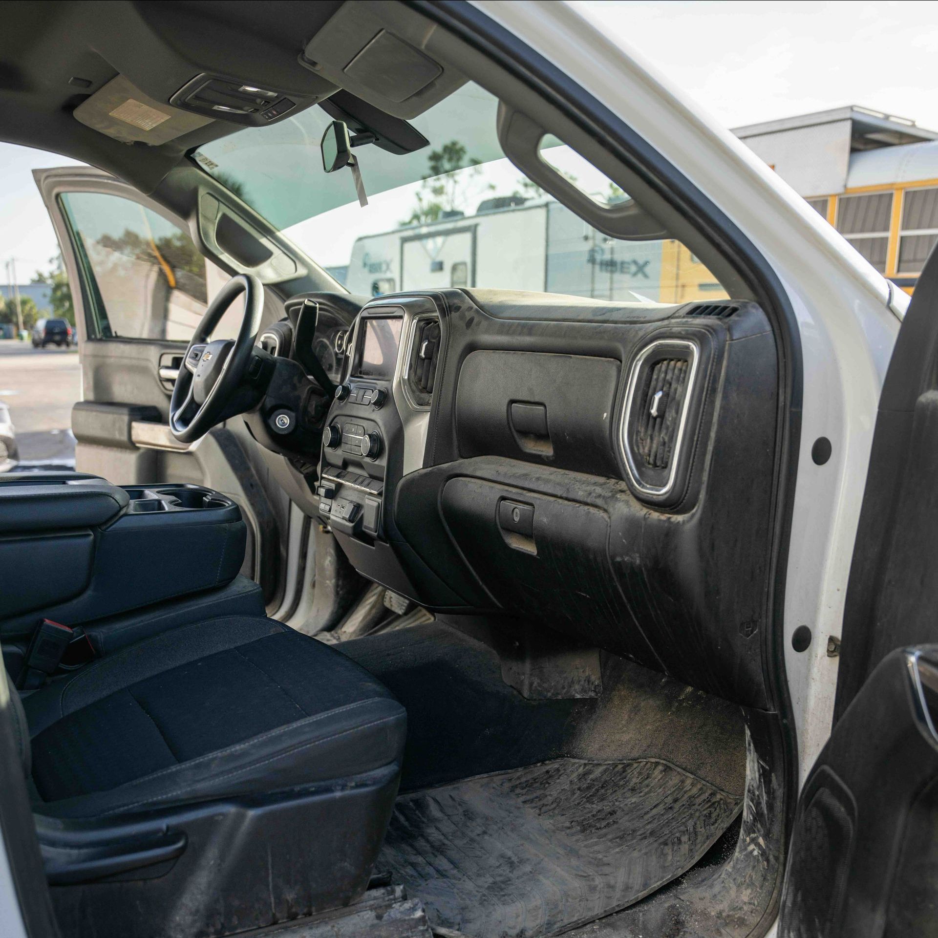 The inside of a white truck with the door open