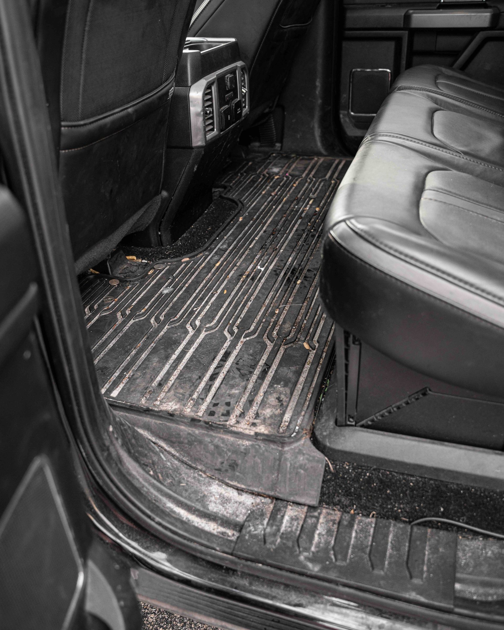 A close up of the inside of a car with a dirty floor.