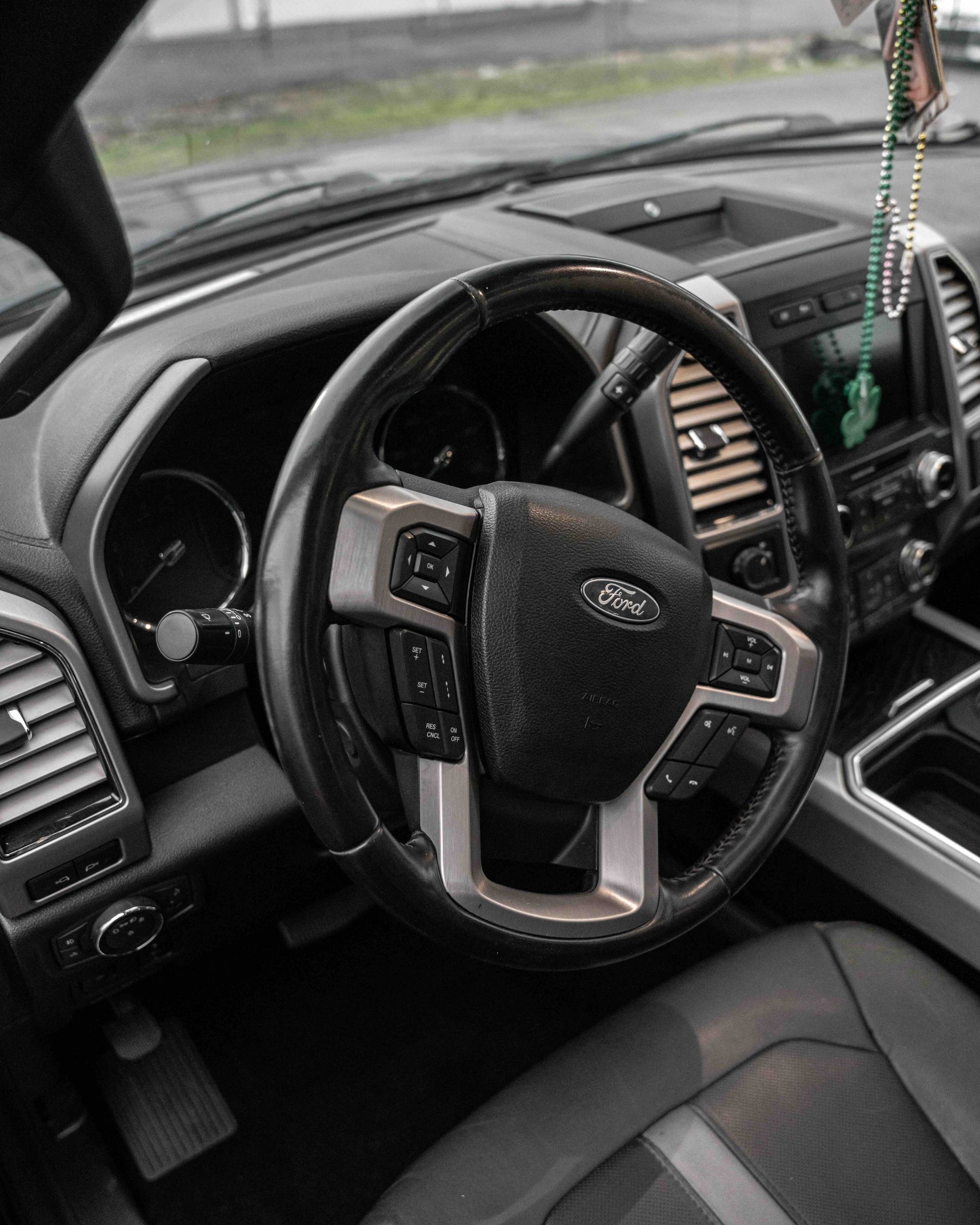 The interior of a ford truck with a steering wheel and dashboard.