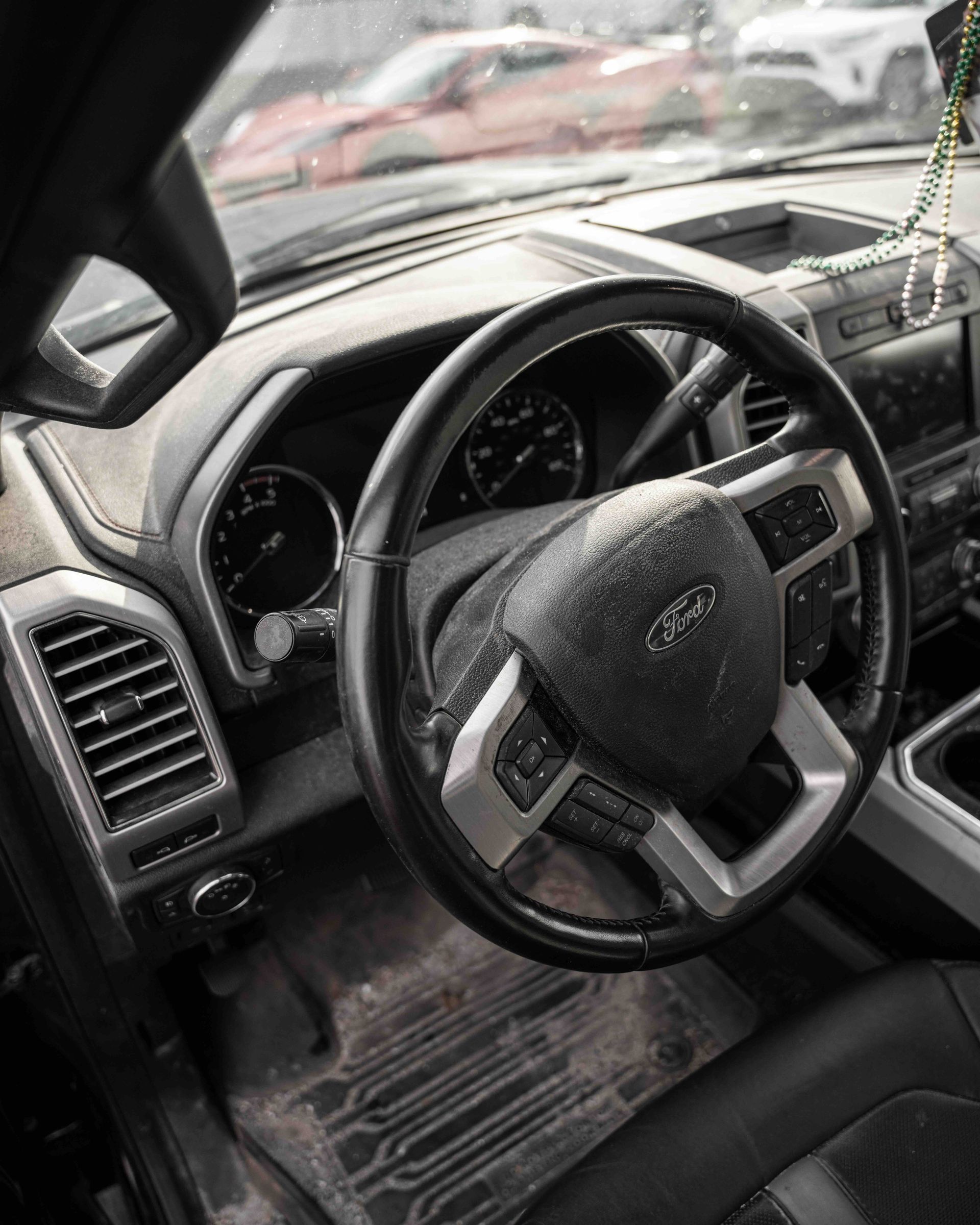 A close up of the steering wheel and dashboard of a car.