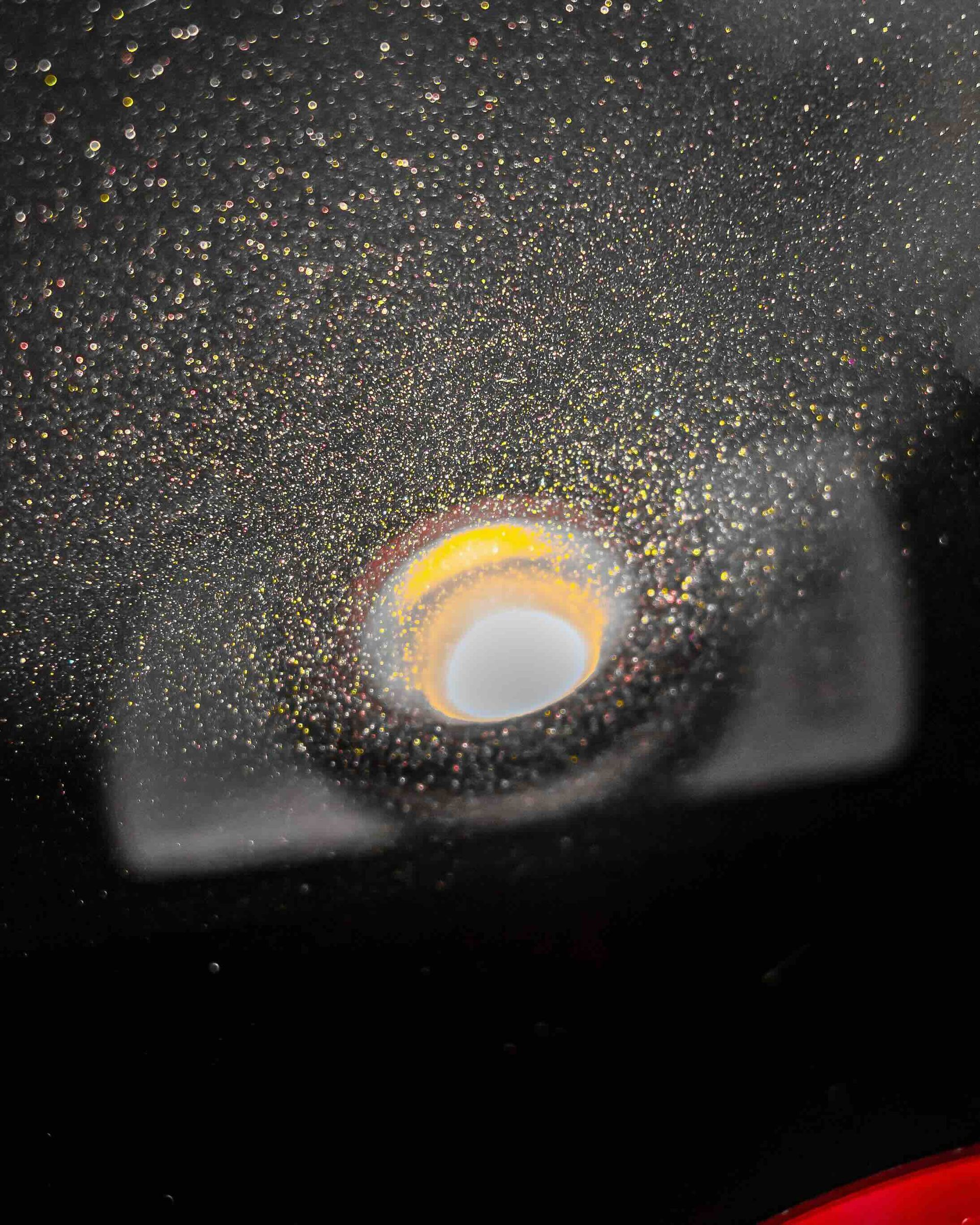 A close up of a light with a lot of sparkles coming out of it.