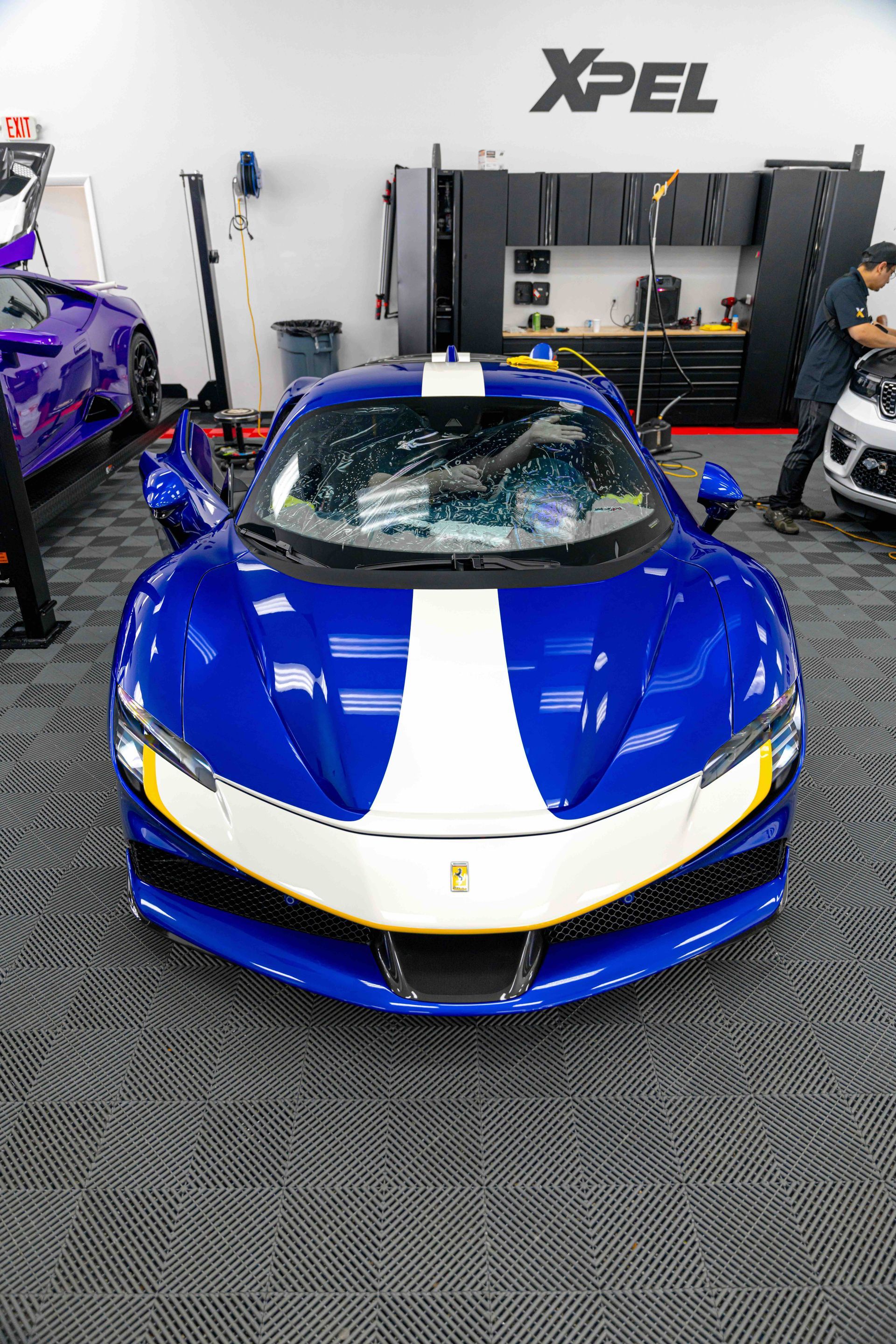 A blue and white sports car is parked in a garage.
