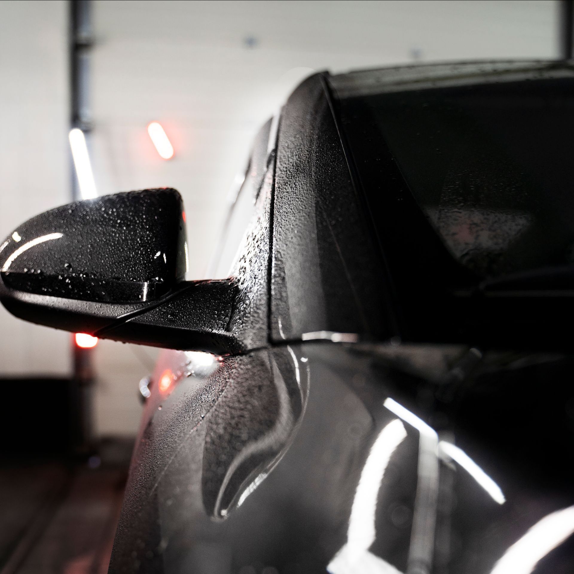 A close up of a car 's side mirror with water drops on it