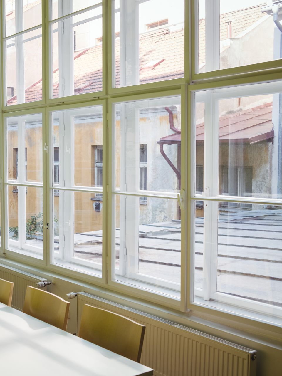 A room with a table and chairs and lots of windows