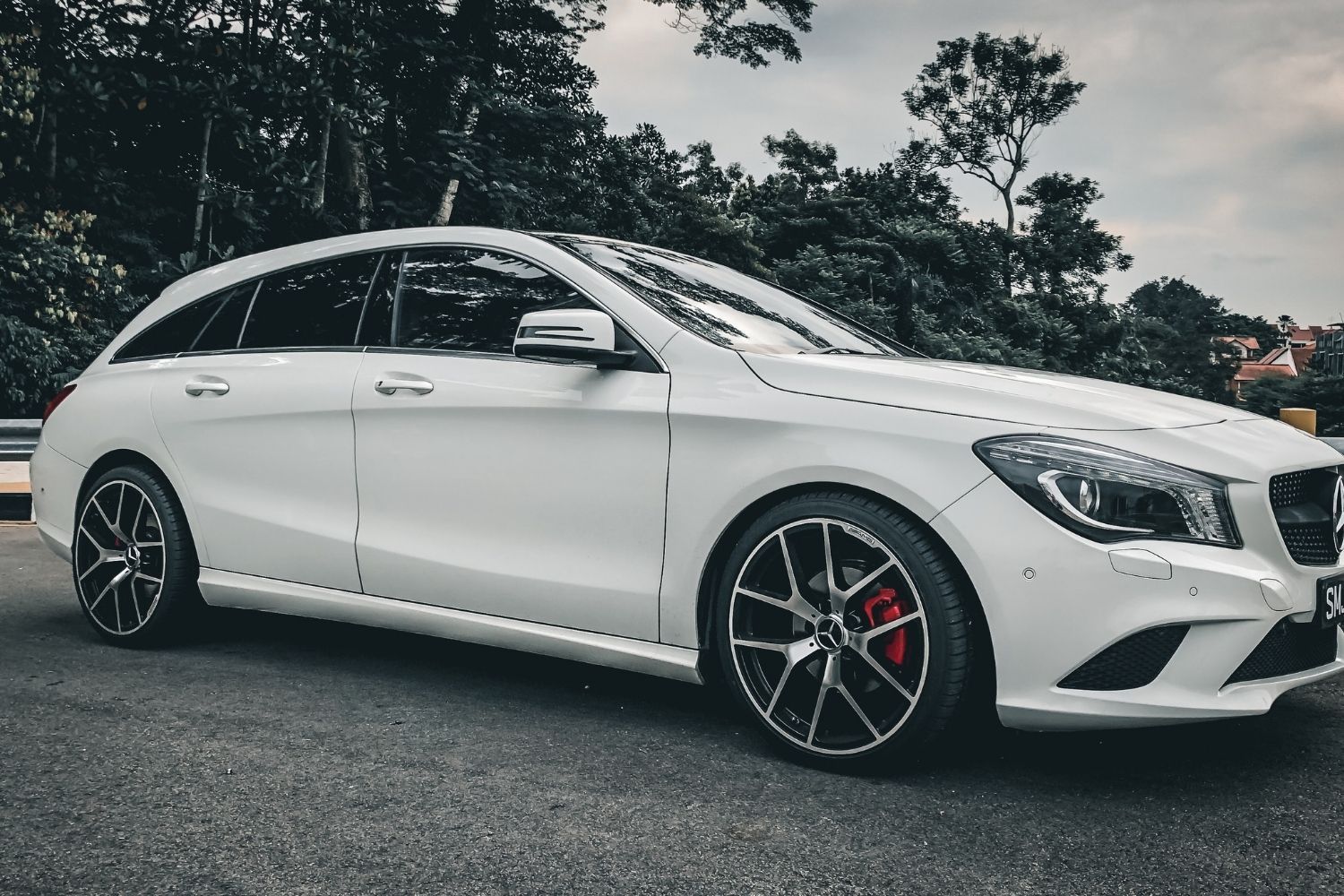 A white mercedes benz cla class station wagon is parked on the side of the road.