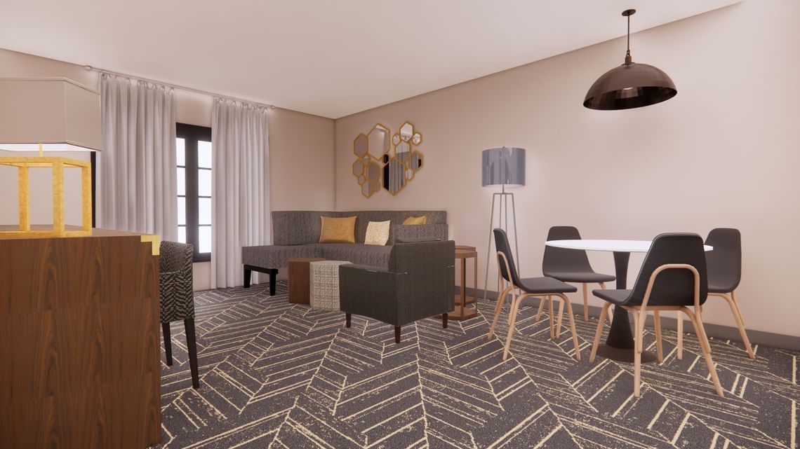 Living and dining room with sofa, chairs, table, and dark gray patterned carpet.