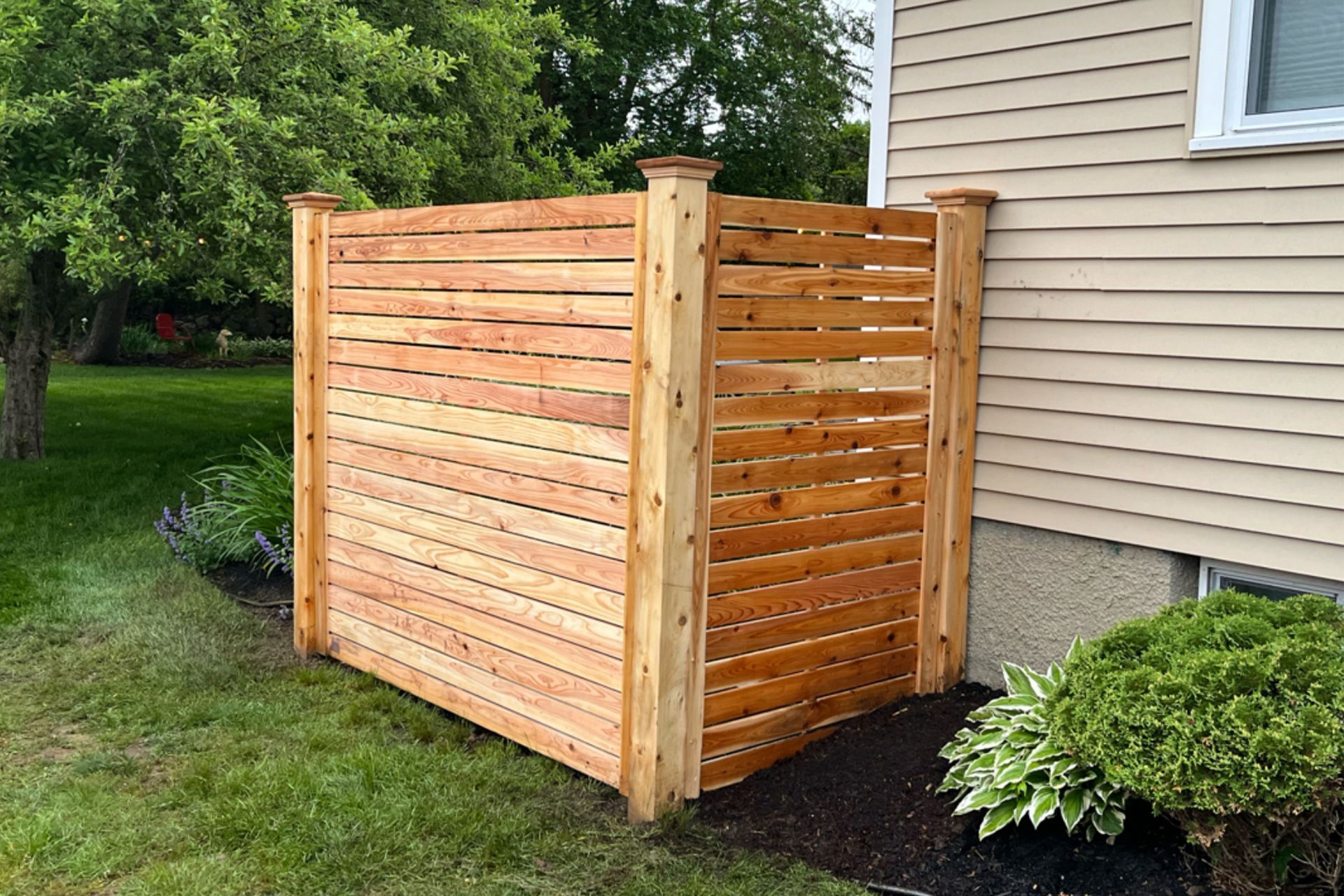 A wooden fence is sitting in front of a house.