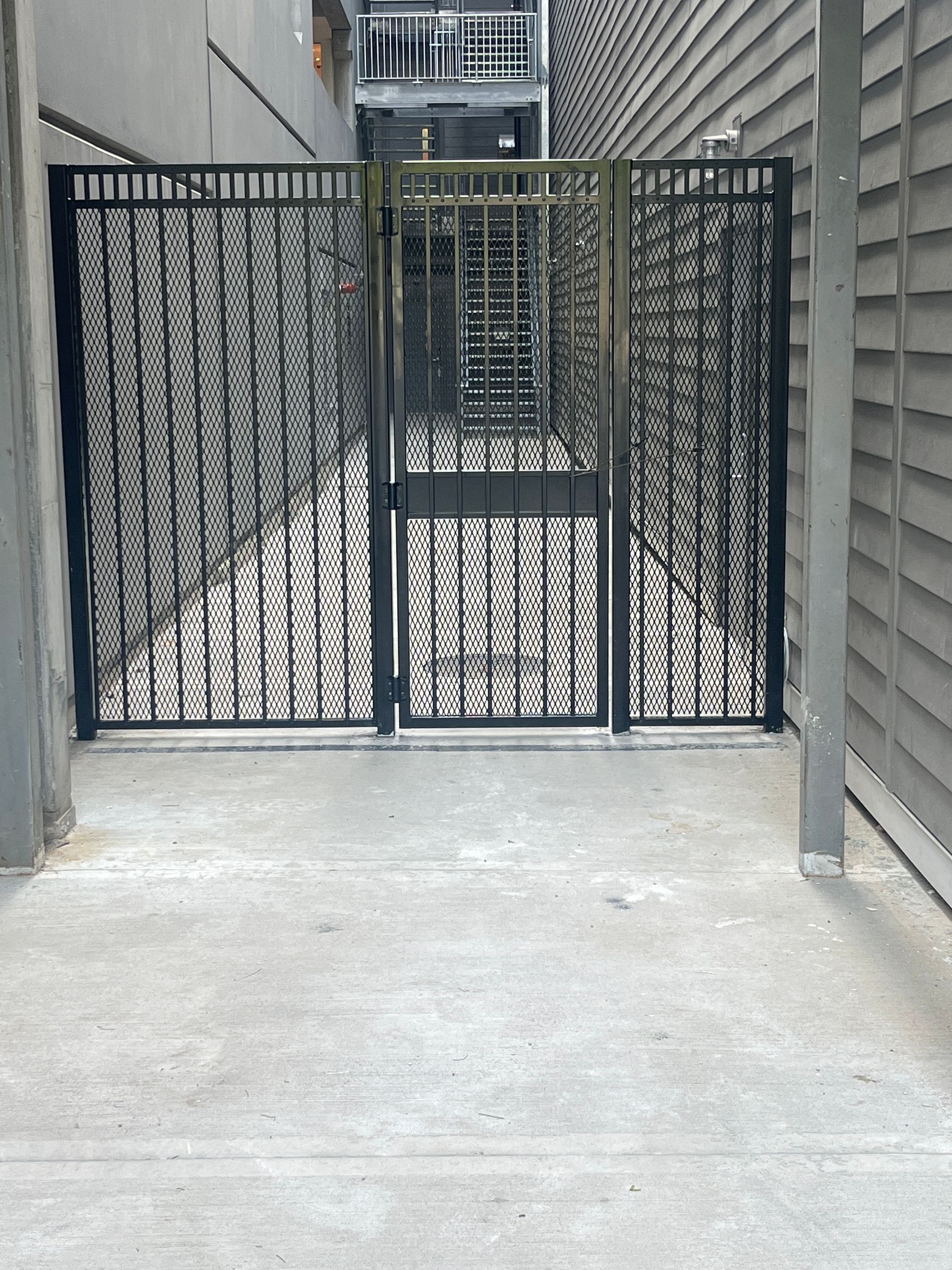 A wrought iron gate with a staircase behind it
