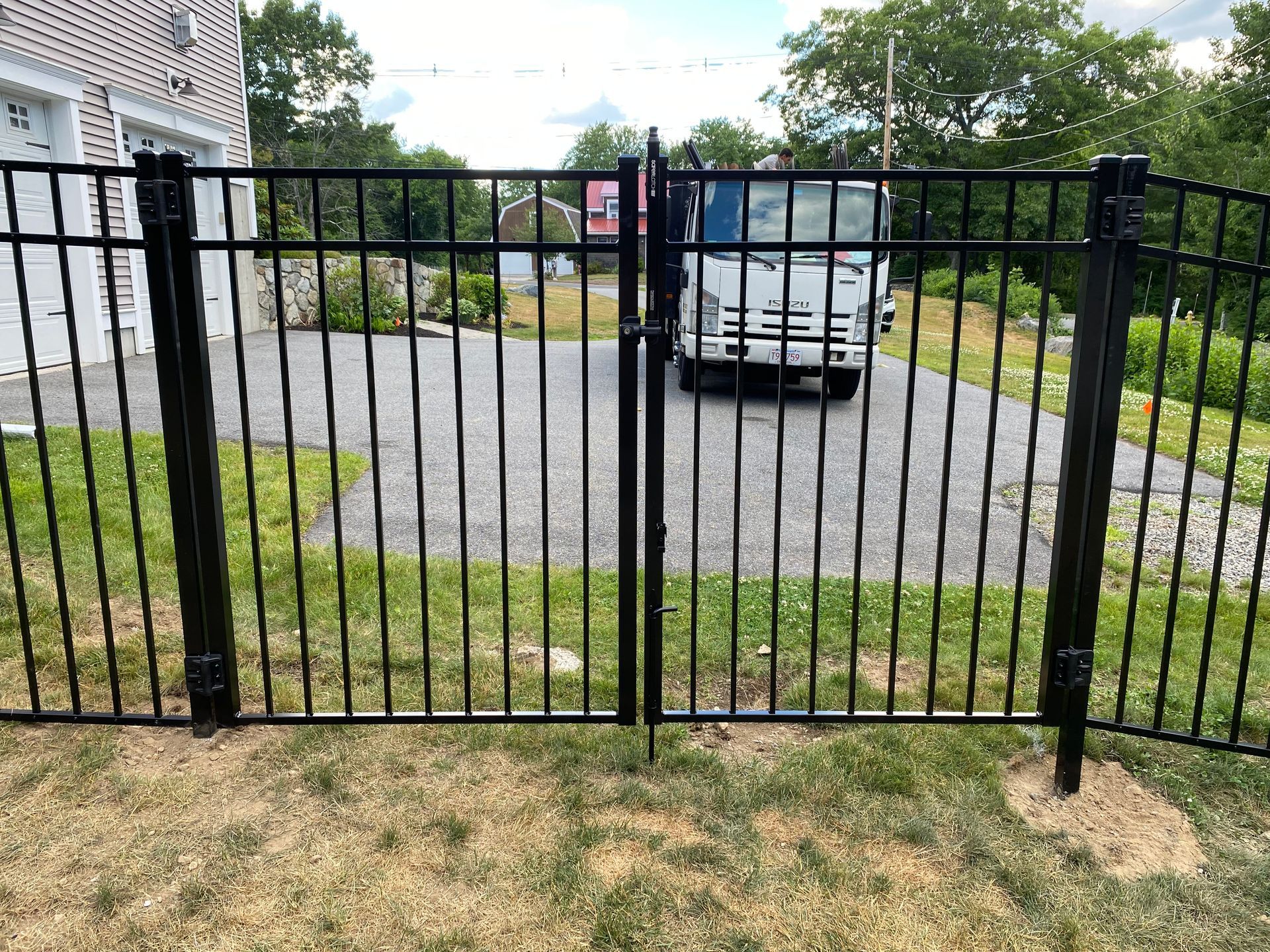 A black metal fence with a truck parked behind it.