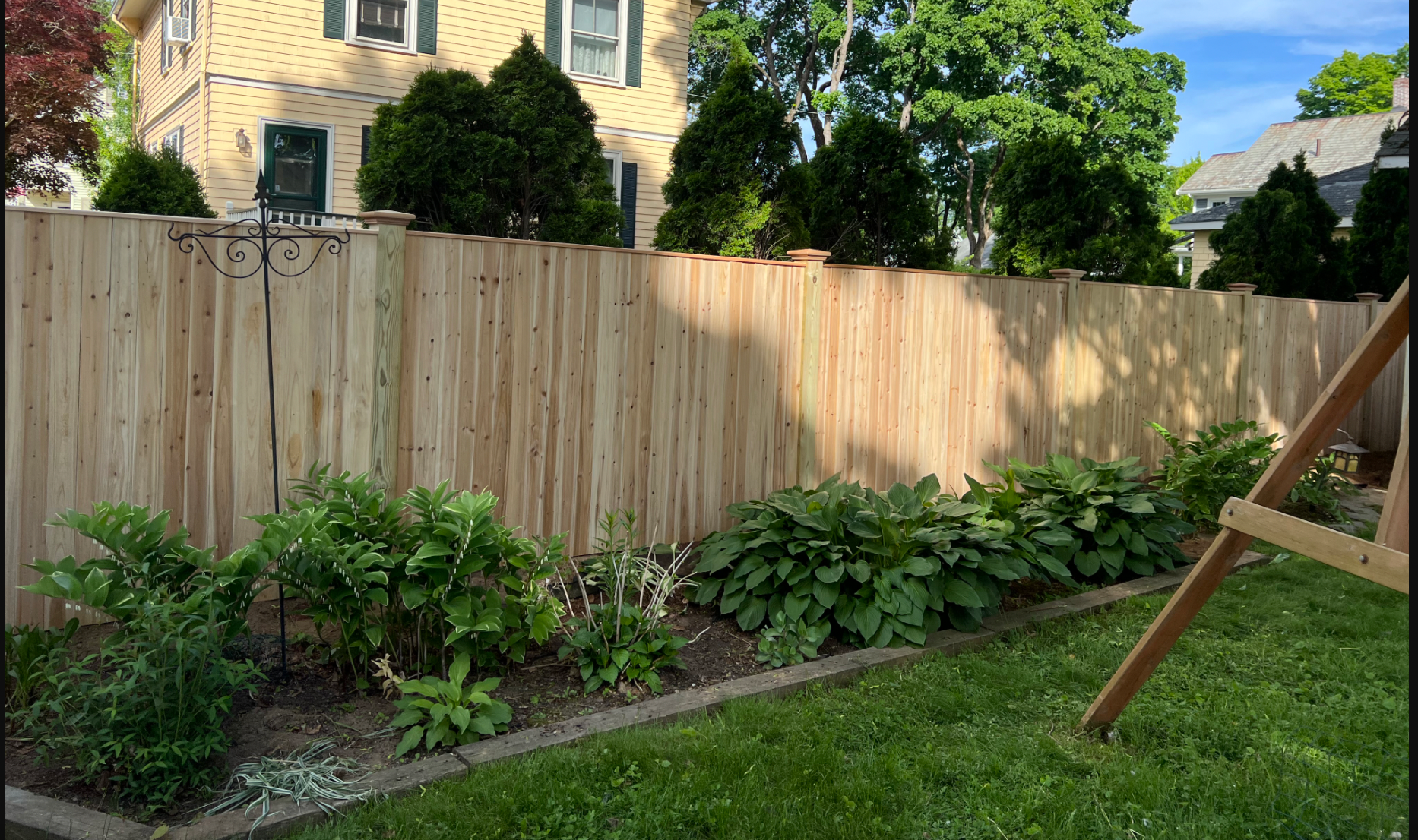 There is a wooden fence in the backyard of a house.