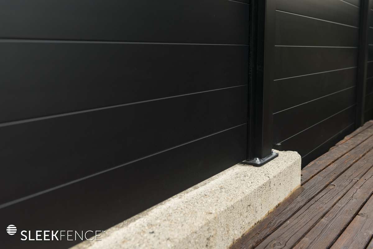A black fence is sitting on top of a wooden deck.