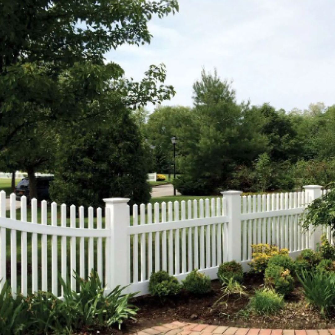 A white picket fence surrounds a lush green field