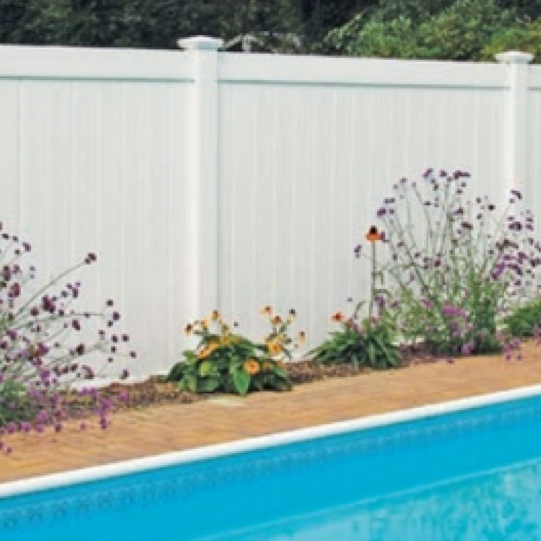 A swimming pool with a white fence surrounding it