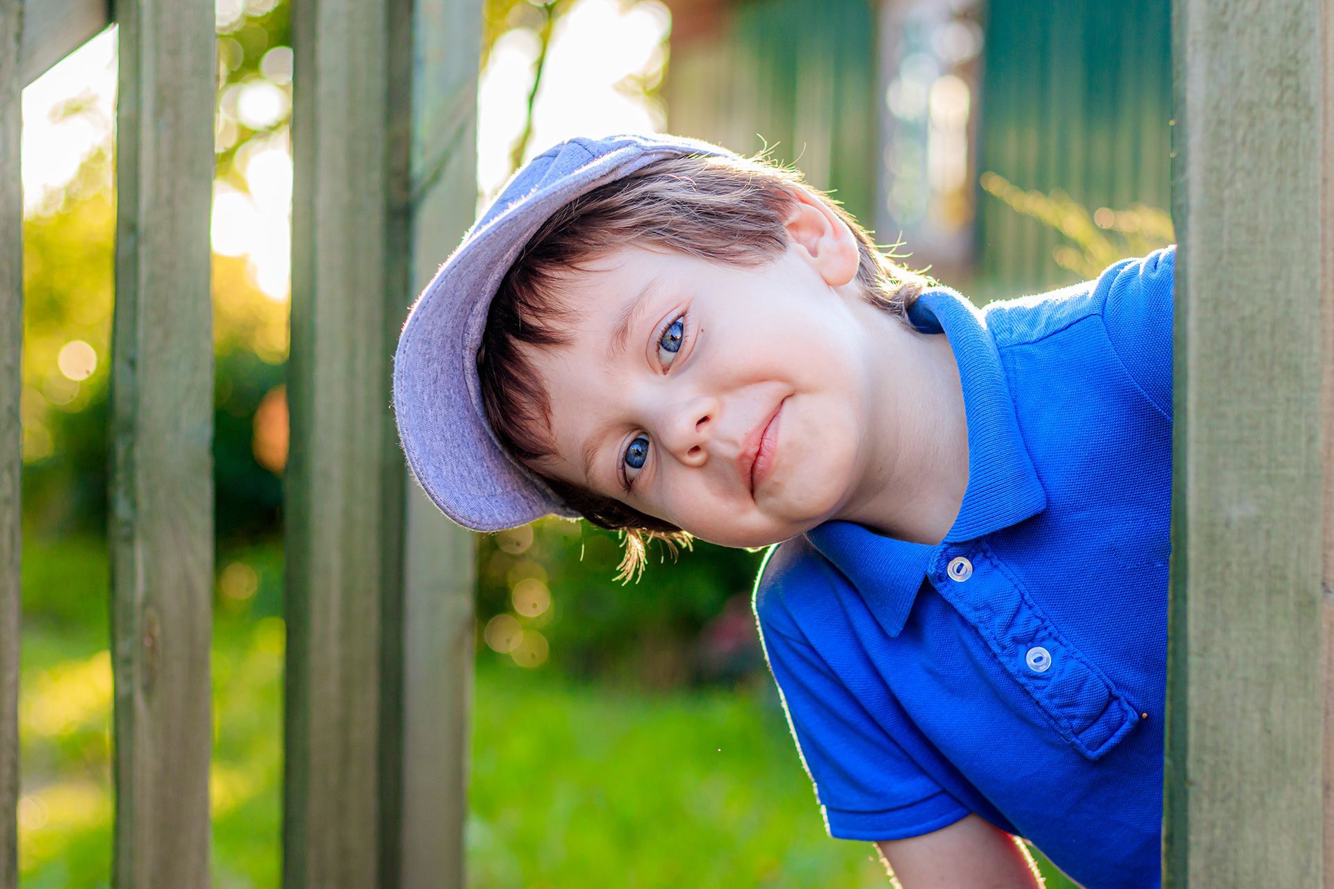 boy looking out from fence