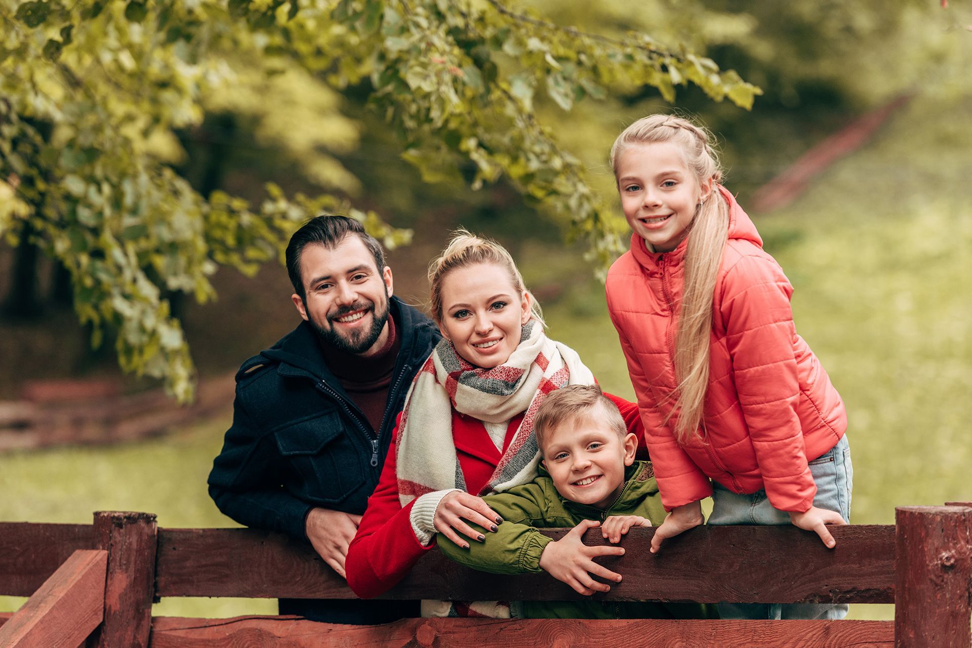 family leaning on fence