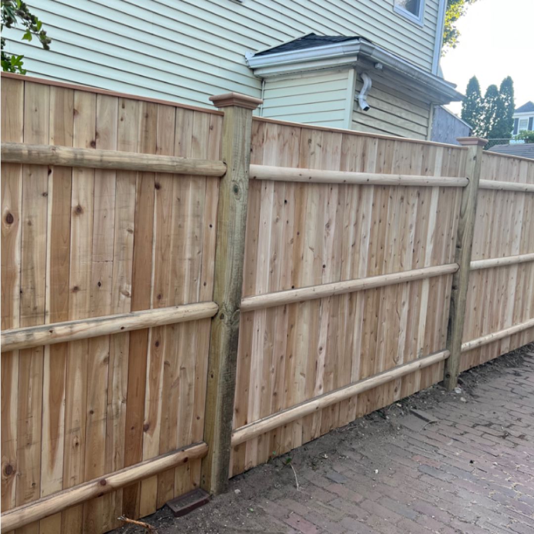 A wooden fence is sitting in front of a house.