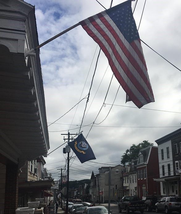 an american flag is hanging from a pole in a city