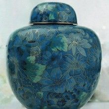 a blue vase with flowers on it is sitting on a table .