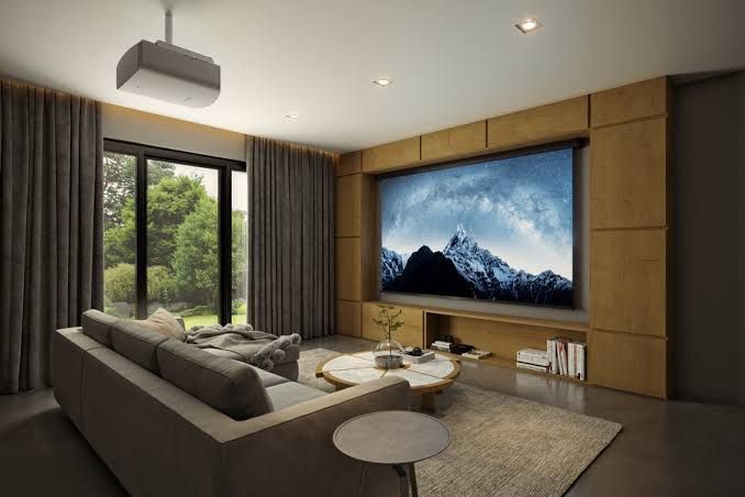 A living room with a large flat screen tv on the wall.