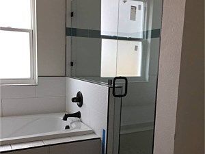 A bathroom with a toilet, shower, and towel rack