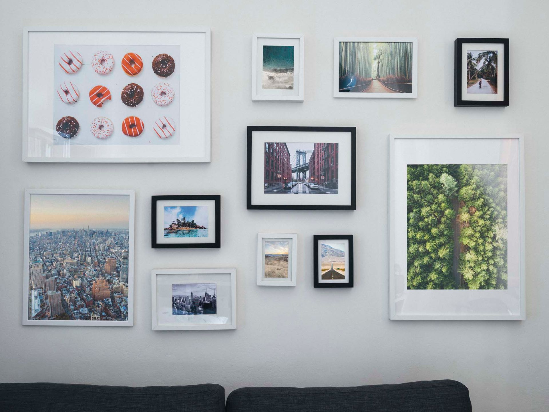 A living room with a couch and a wall filled with pictures