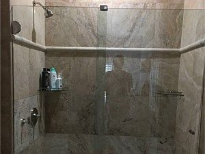 A bathroom with a walk in shower, toilet, sink and mirror