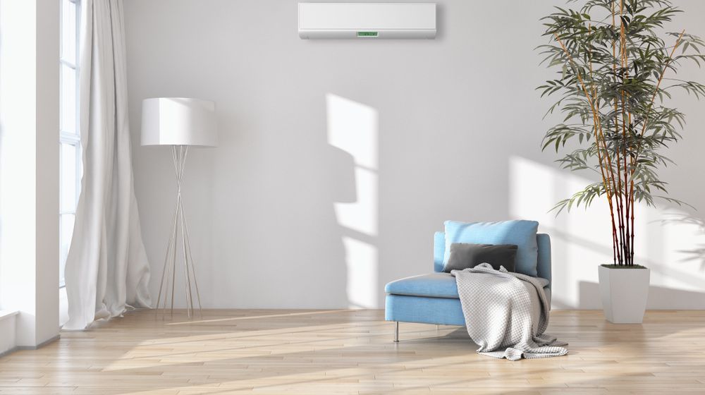 Living Room With A Blue Chair And Air Conditioner On The Wall — Oriel Refrigeration and Air Conditioning in Warren, NSW