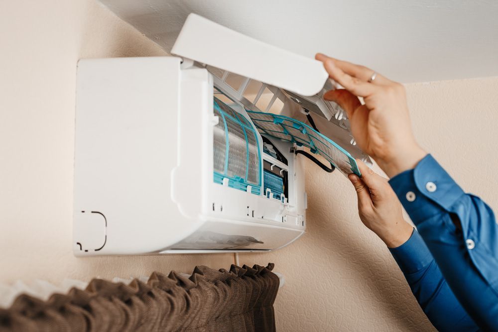 Man Cleaning The Filter Of The Air Conditioner — Oriel Refrigeration and Air Conditioning in Narromine, NSW