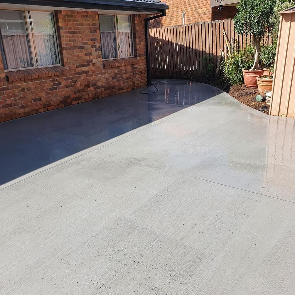 A Brick House with A Concrete Driveway in Front of It — Kontek Constructions in Jimboomba, QLD