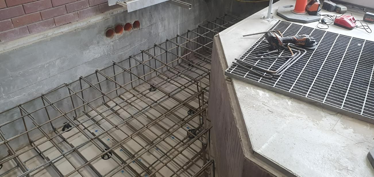 A Metal Grate Is Sitting on Top of A Concrete Floor — Kontek Constructions in Brisbane, QLD