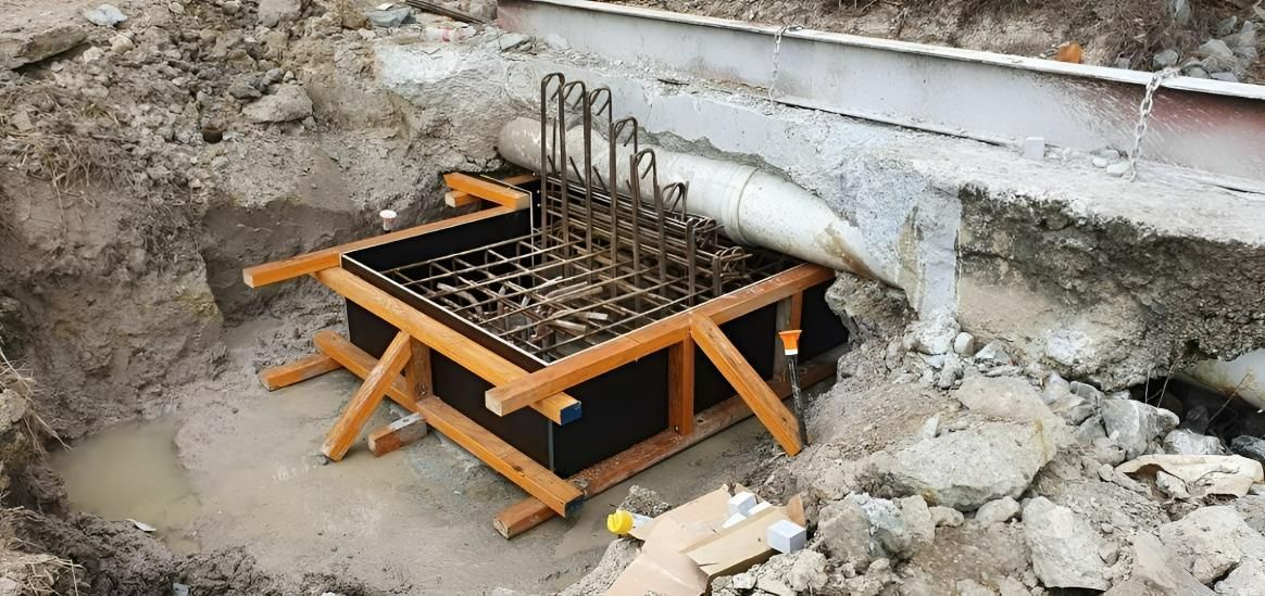 A Wooden Box Is Sitting in The Dirt Next to A Drainage — Kontek Constructions in Jimboomba, QLD