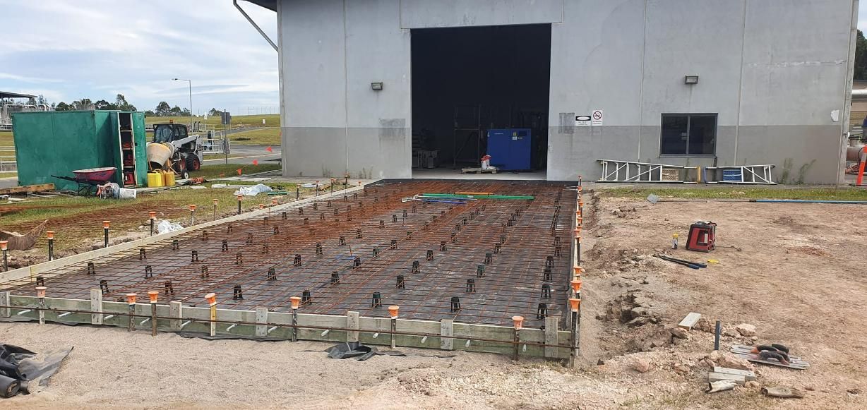 A Building Under Construction with A Lot of Concrete in Front of It — Kontek Constructions in Beaudesert, QLD