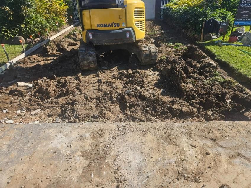 A Yellow Komatsu Excavator Is Digging in The Dirt — Kontek Constructions in Jimboomba, QLD