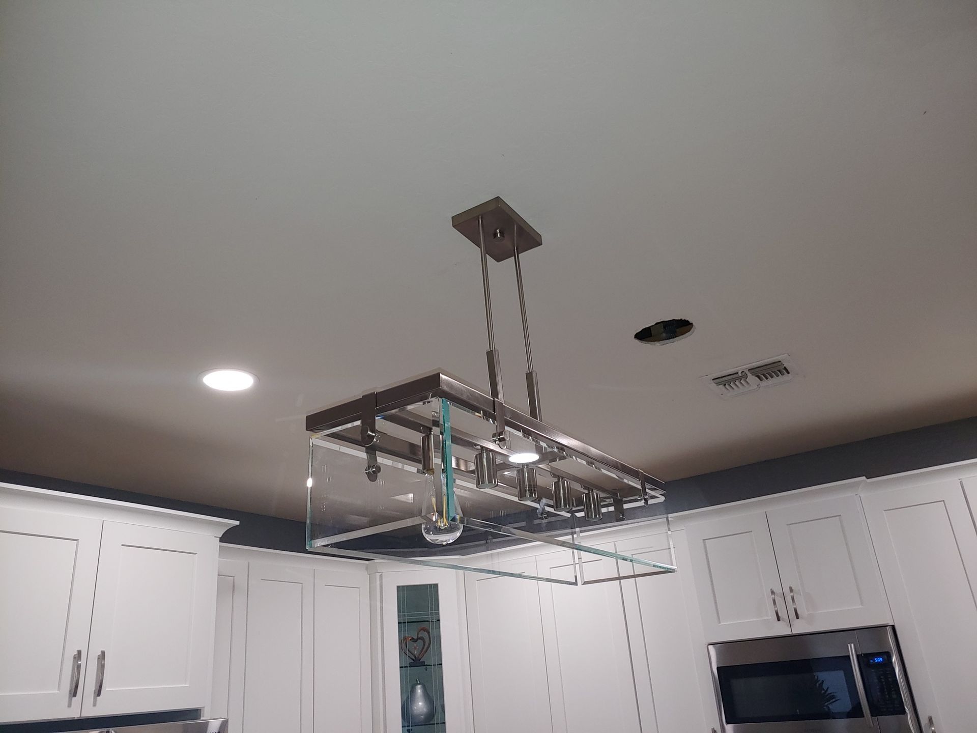 A kitchen with a ceiling light hanging from it