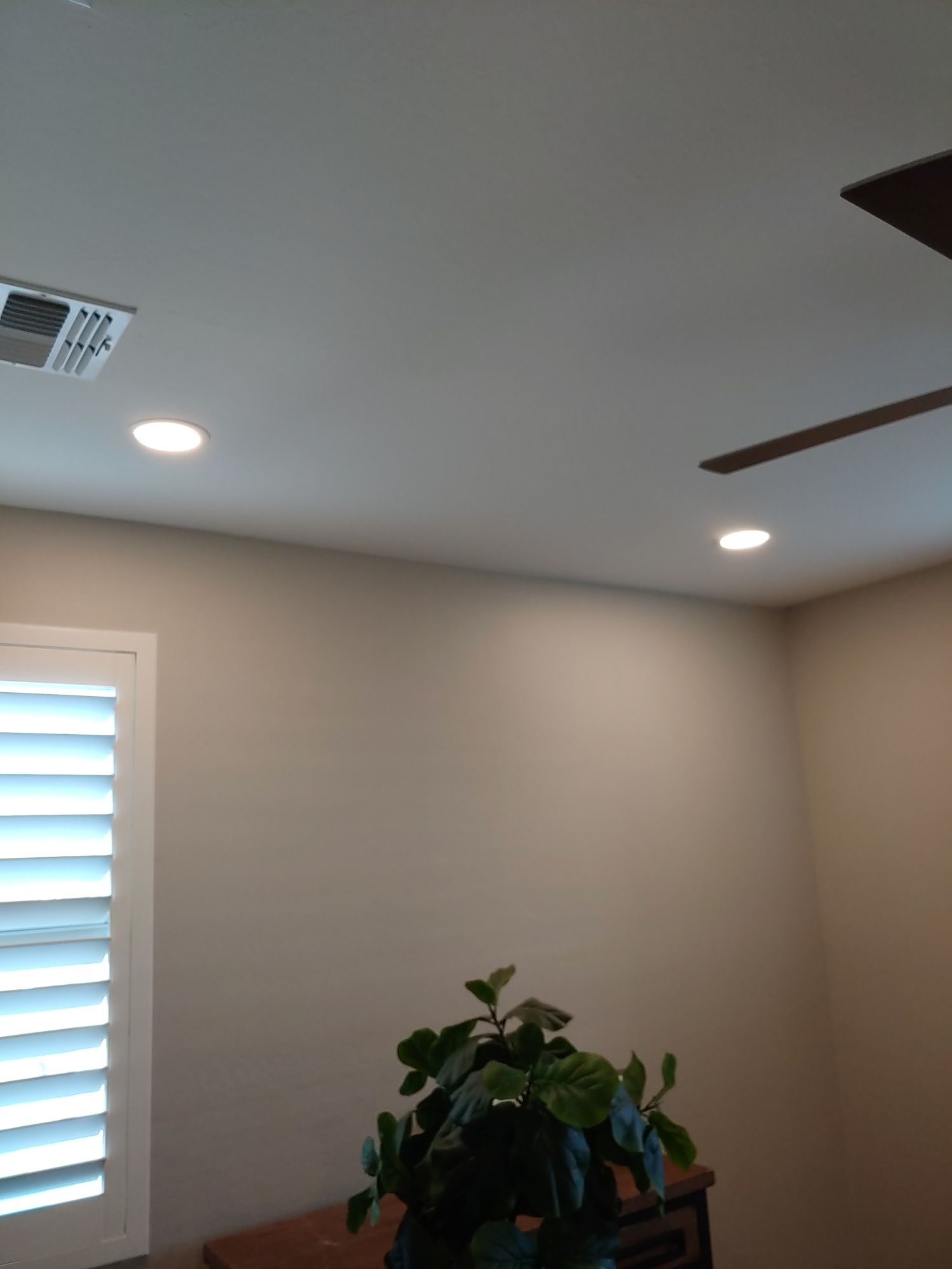 A room with a ceiling fan and a window