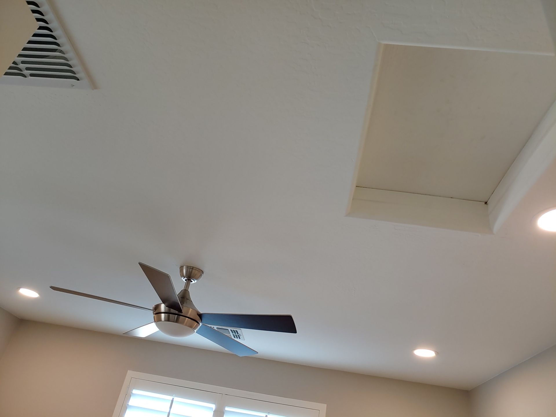 A ceiling fan is hanging from the ceiling of a room.
