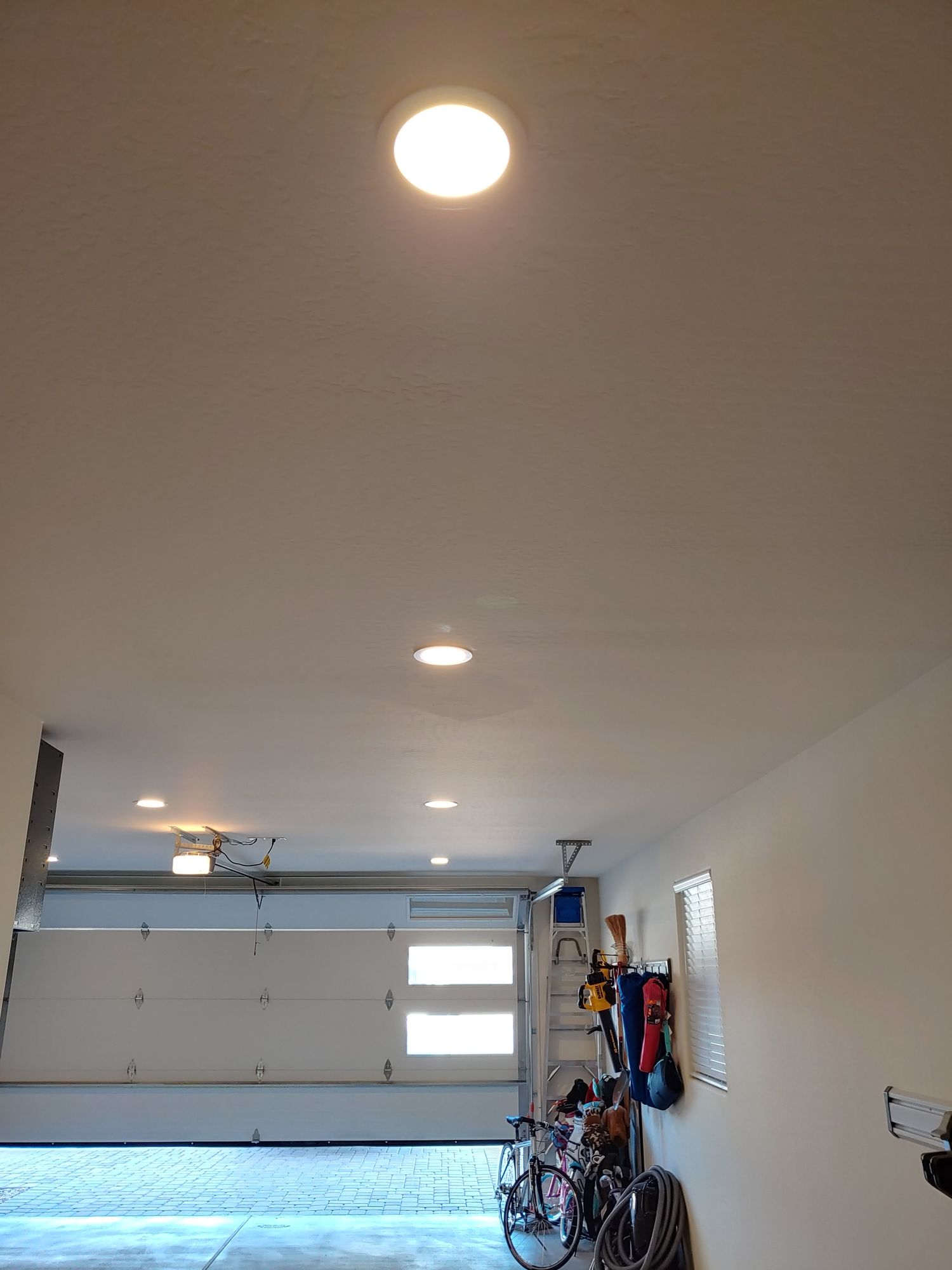 A garage with a door open and a light on the ceiling.
