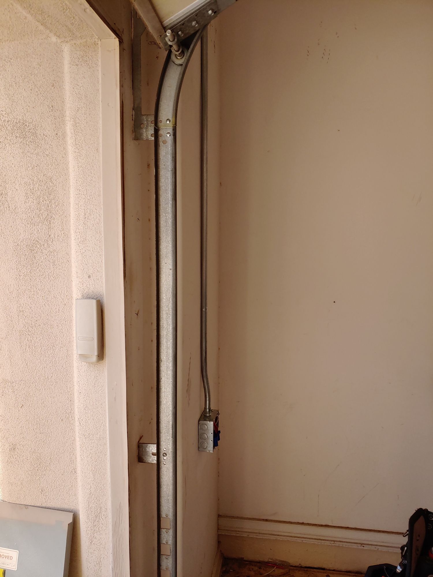 A garage door is open in a room next to a wall.