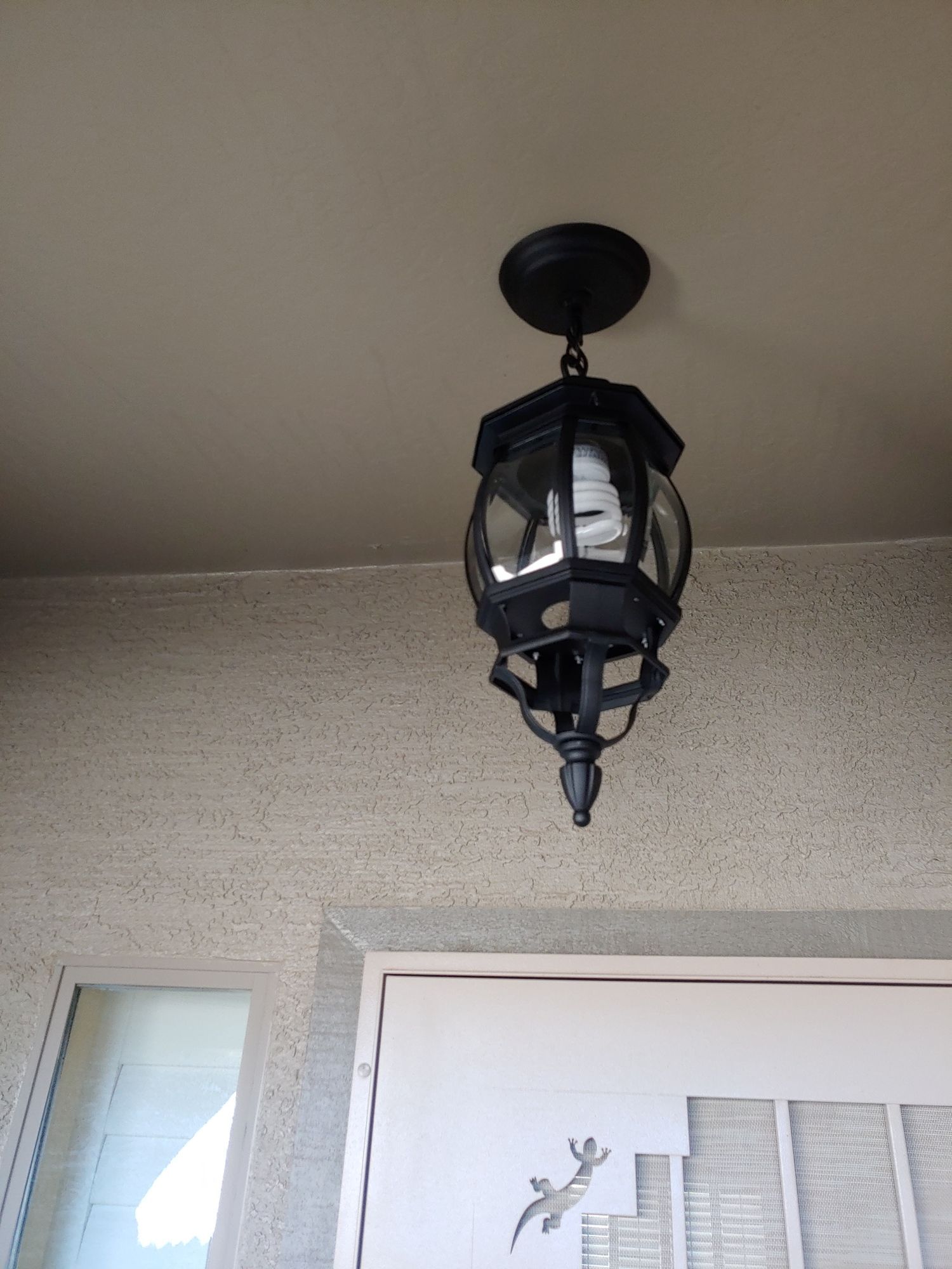 A black lantern is hanging from the ceiling above a door.