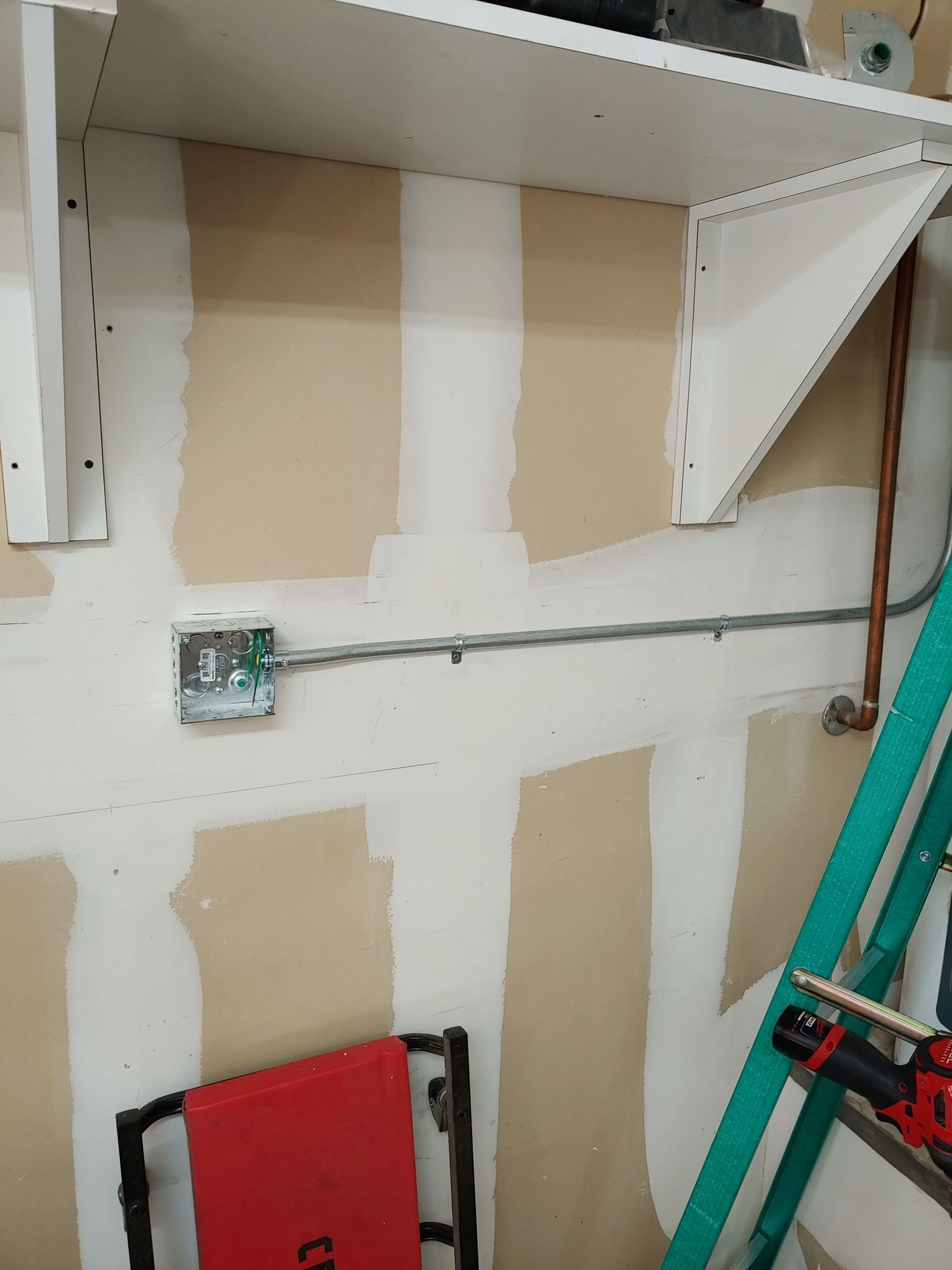 A ladder is sitting next to a shelf in a room.