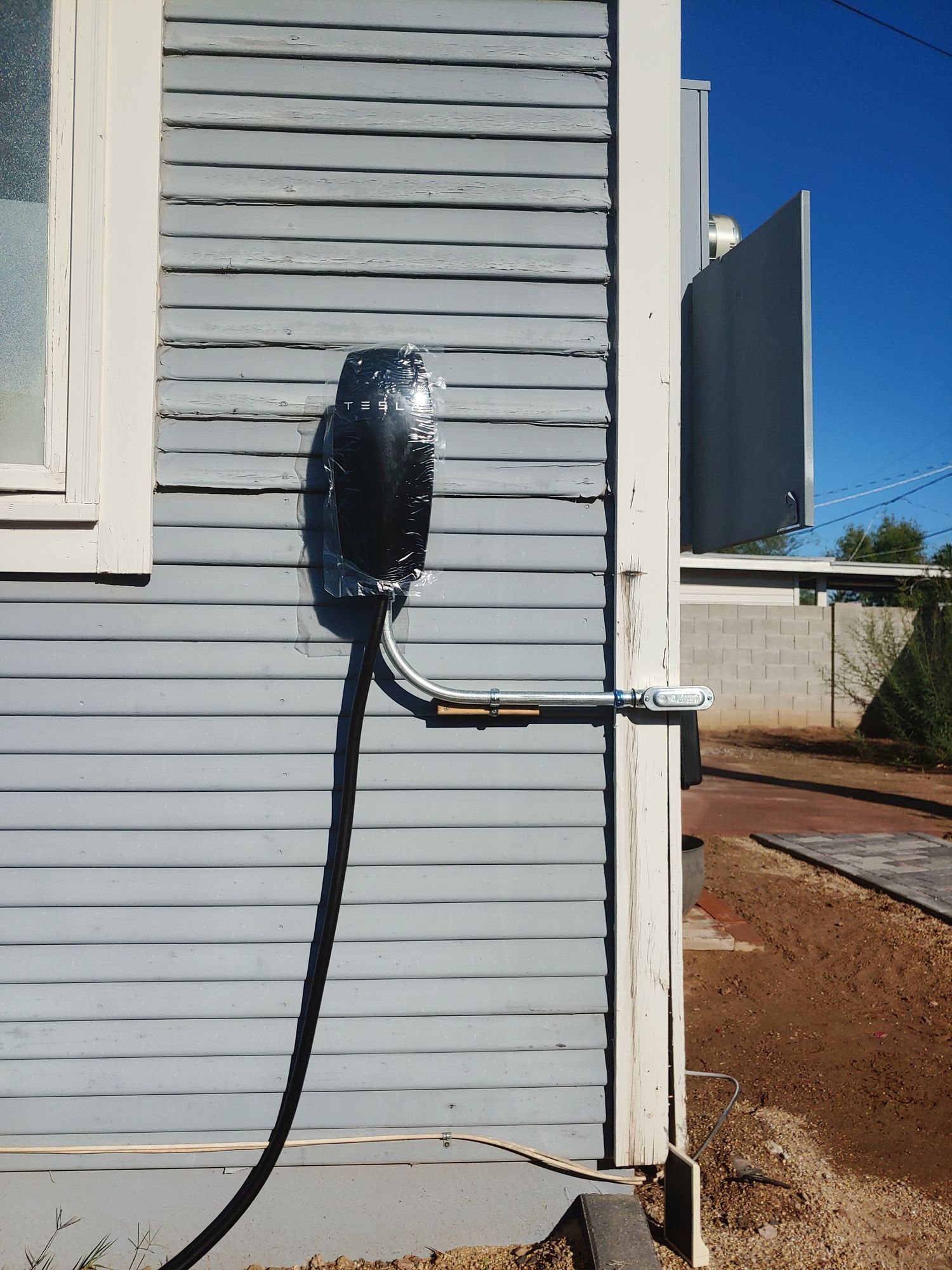 A black cord is attached to the side of a building